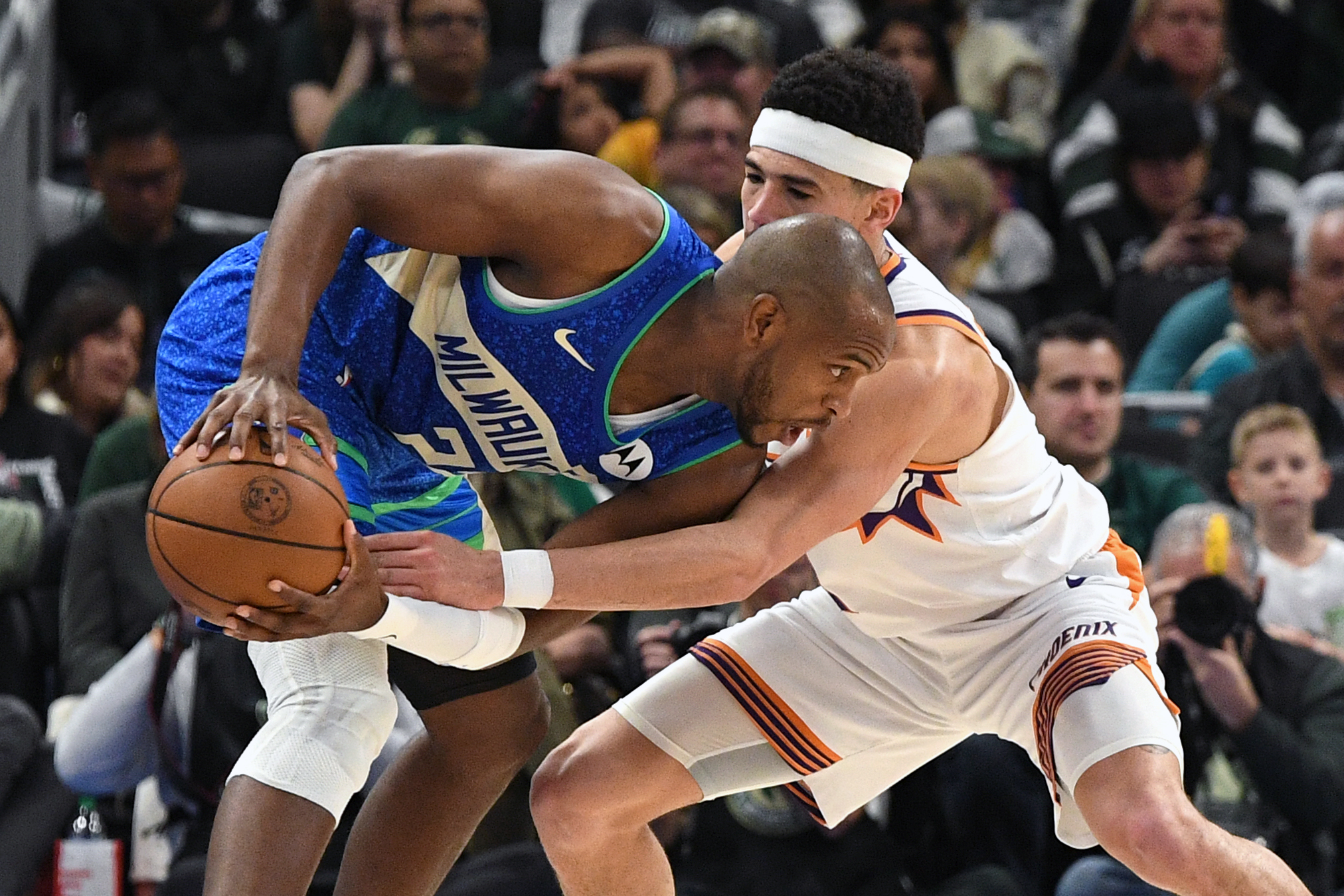 Phoenix Suns guard Devin Booker (1) defends against Milwaukee Bucks forward Khris Middleton (22) 